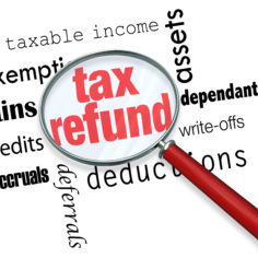A magnifying glass hovering over several words, at the center of which is Tax Refund